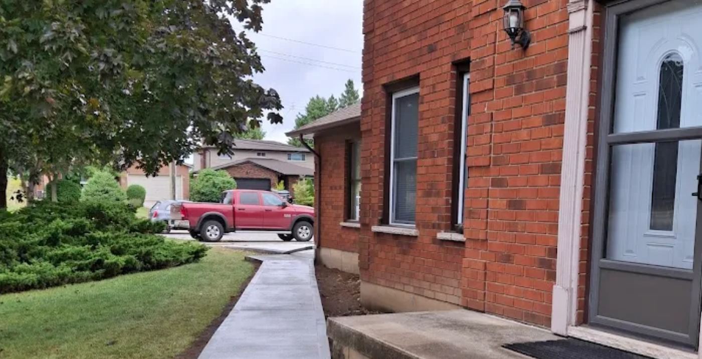 Concrete walkway and landing at a brick home